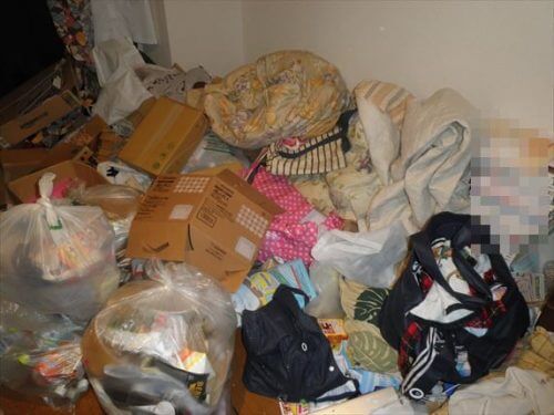 布団、衣類をはじめ床一面に広がるゴミ屋敷の不用品